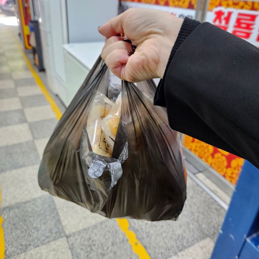 피자설기를 담은 봉지를 든 손